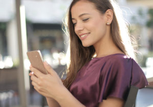Young woman looking on her phone, outside