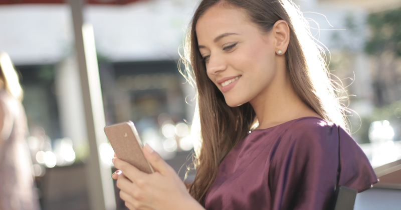 Young woman looking on her phone, outside